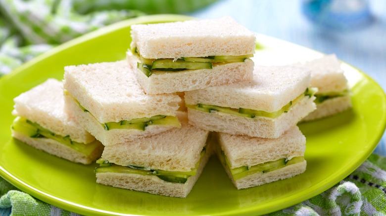 Square cucumber sandwiches on a green plate