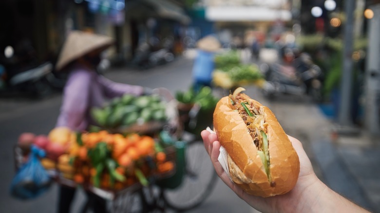 man holding banh mi in Vietnam