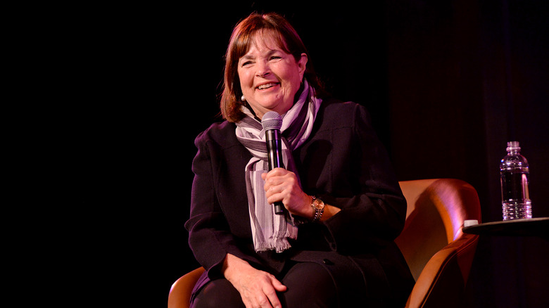 Ina Garten holds a microphone on stage at a speaking event