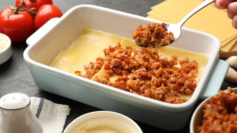 Assembling lasagna in a baking pan