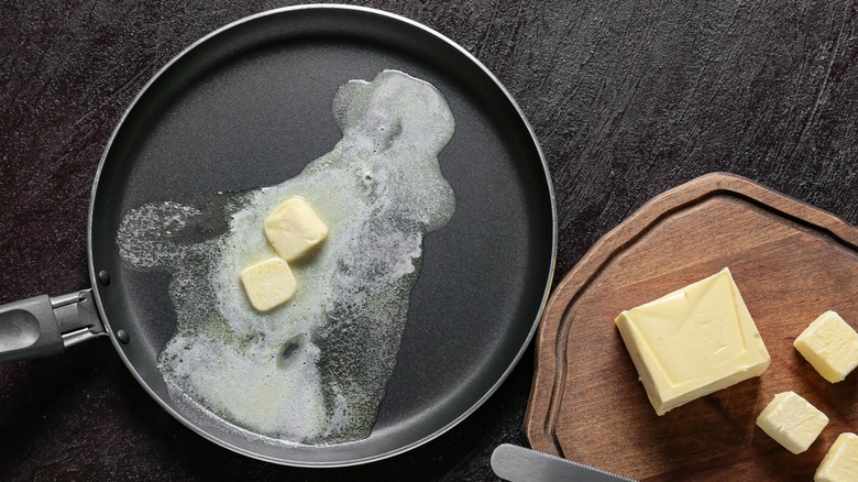 Butter melting in a frying pan next to solid butter. 