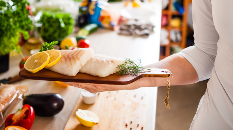 Person presenting cleaned fish fillets