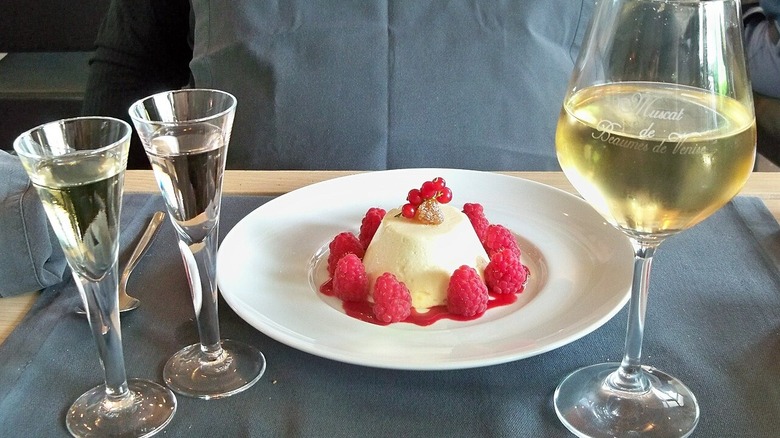 A glass of Muscat de Beaumes-de-Venise next to a lemon and raspberry flan.