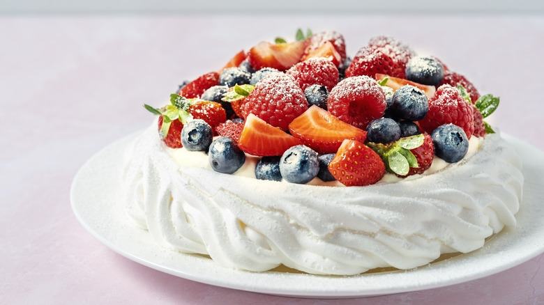 A pavlova with mixed berries on top