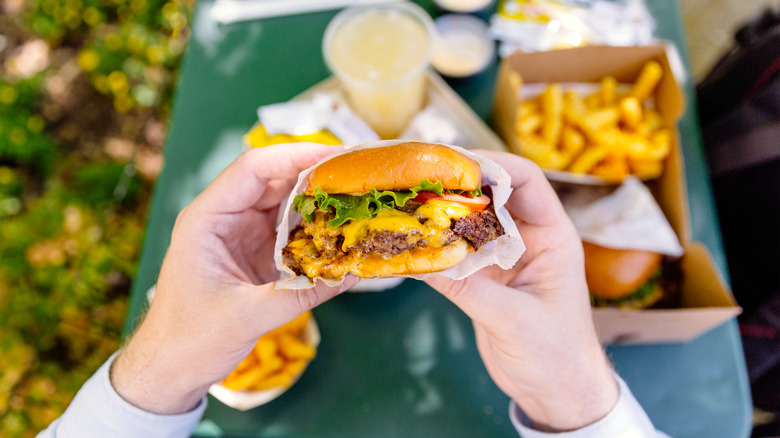 Person holding a cheeseburger