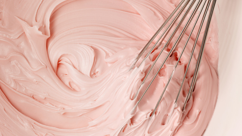 Whisking together homemade pink frosting