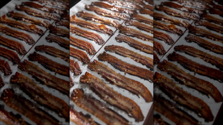 Rows of bacon on baking sheet