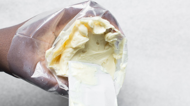 filling a piping bag with frosting