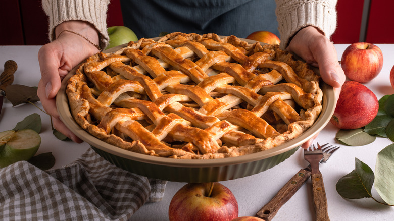 Woman holding lattice topped pie