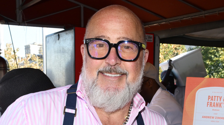 Smiling Andrew Zimmern wearing an apron.