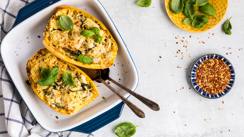 Spaghetti squash topped with cheese and fresh basil leaves