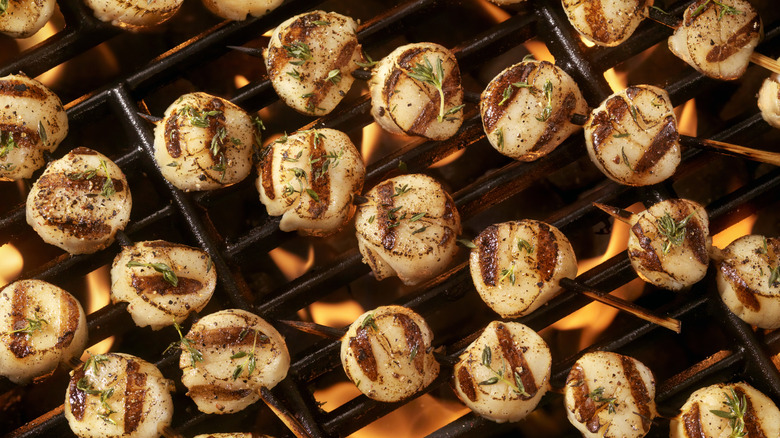 Several scallop skewers on a grill