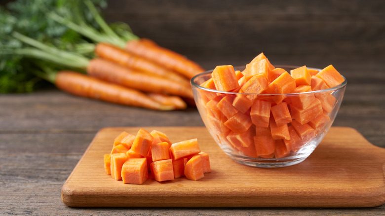 Bowl of diced carrots on a cutting board