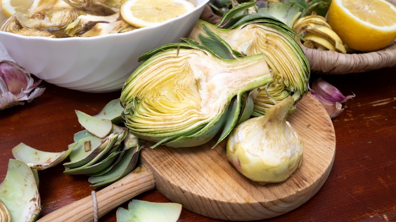 Halved artichoke on wooden board