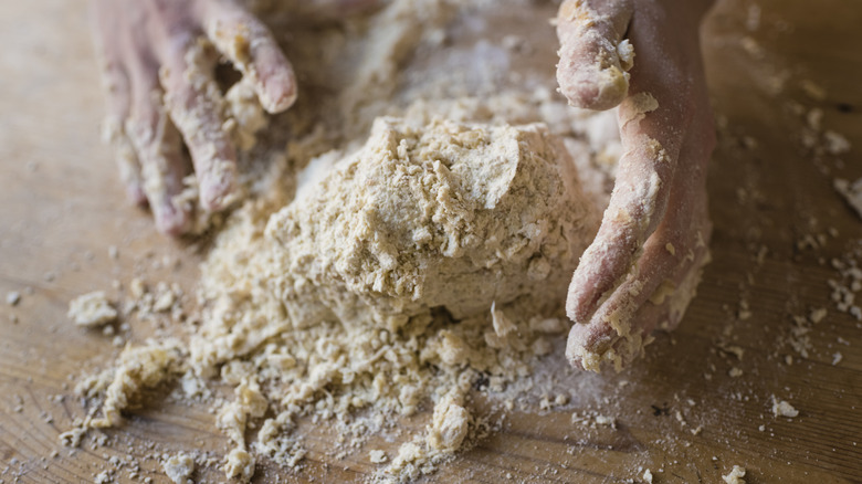 Kneading pie dough on a wooden counter