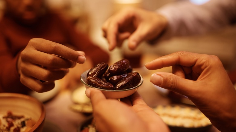 group of people reaching for dates