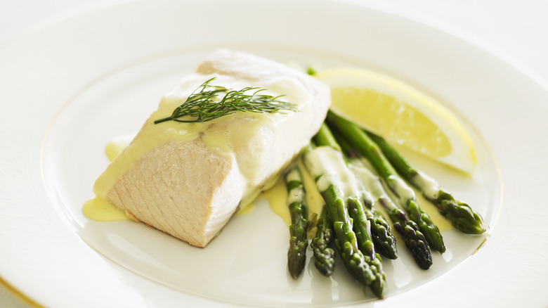 cooked salmon with hollandaise sauce, asparagus, and lemon