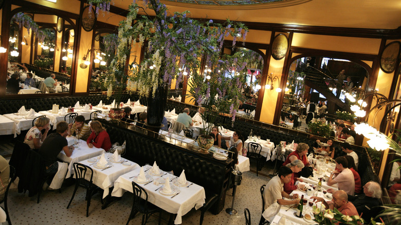 A lovely, dimly lit restaurant dining room with white tablecloths