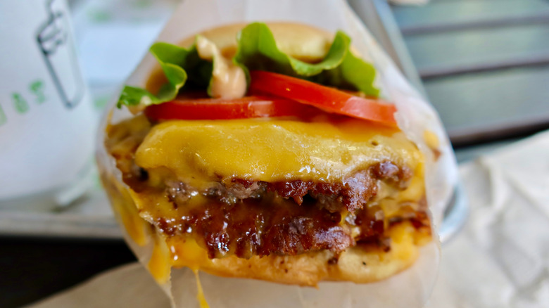 Shackburger with a meaty patty, cheese, tomatoes, and lettuce