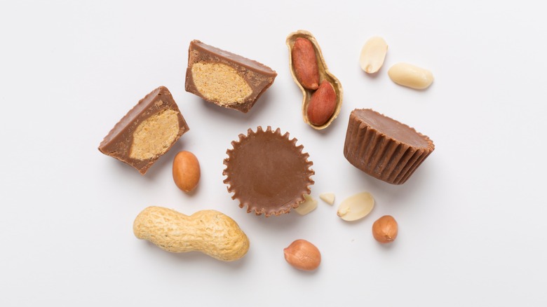 Peanut butter cups and peanuts on a white background