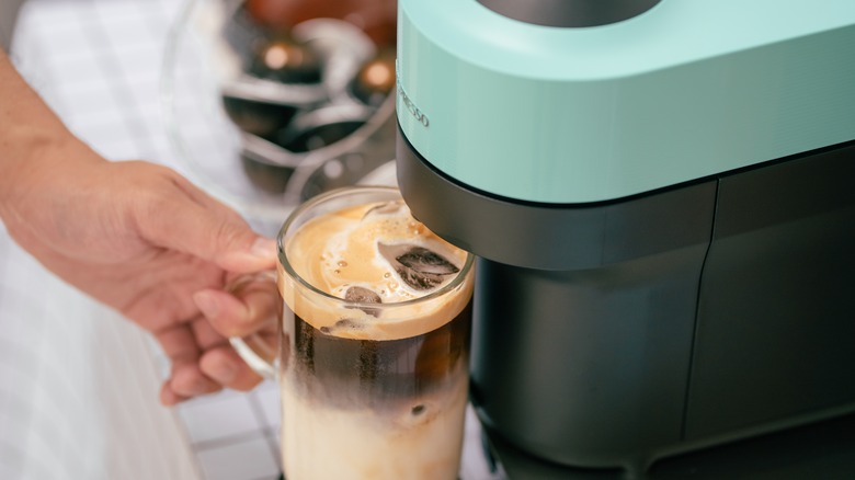 Pouring a Nespresso latte into a glass