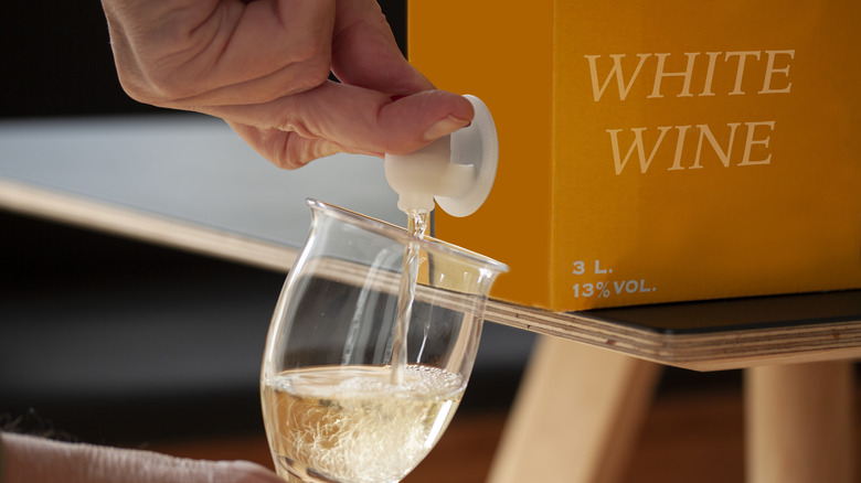 Pouring white wine from a box