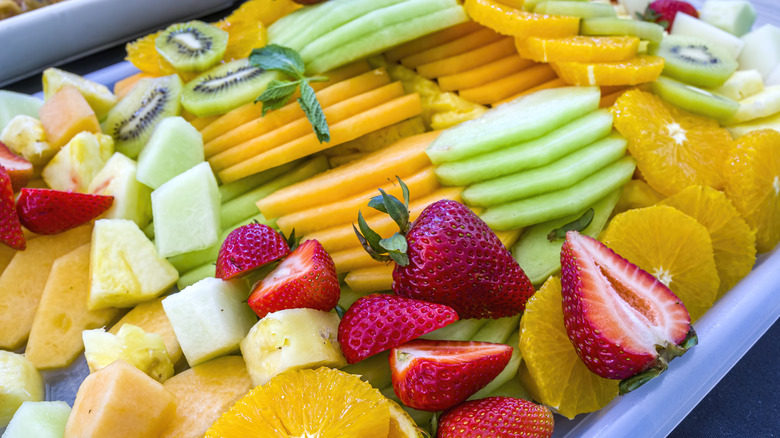 Plate filled with various sliced fruits.