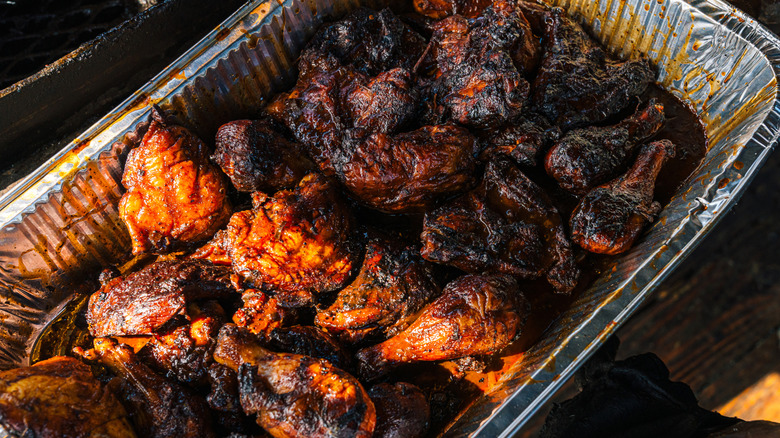 BBQ chicken pieces in tinfoil tray