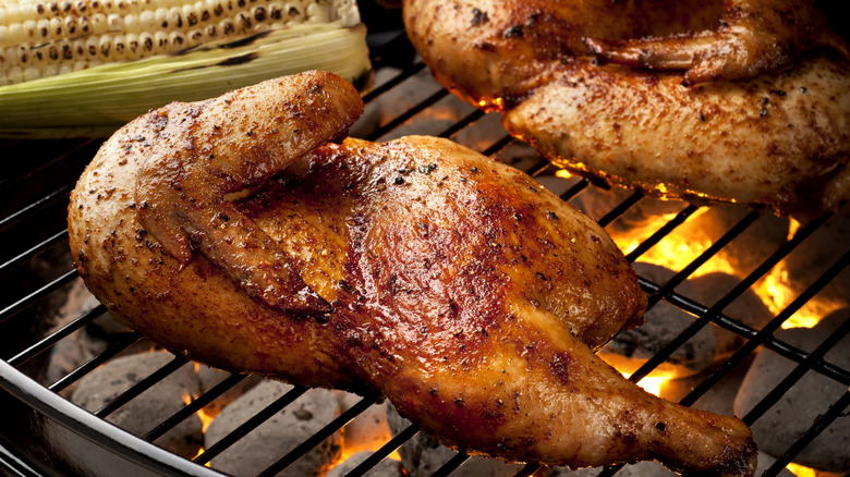 Whole chicken on grill with corn