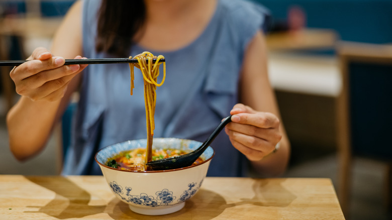 Eating a bowl of noodle soup in Chinese restaurant