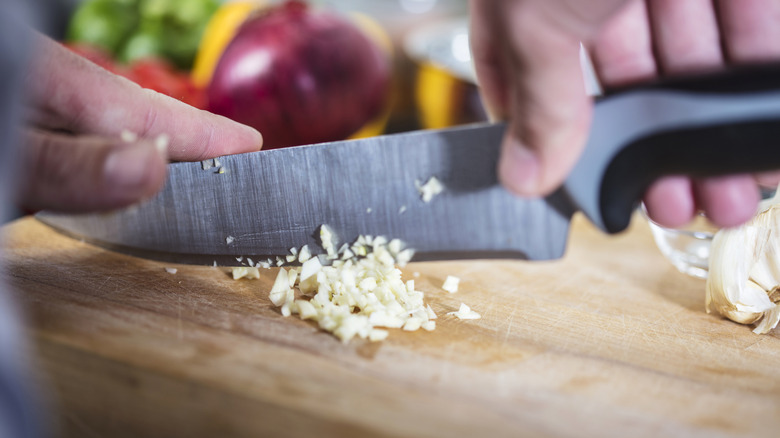 Chopping garlic on cutting board