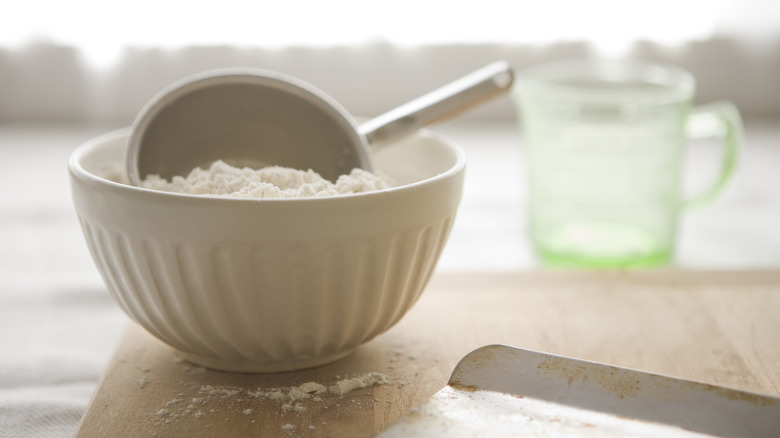 measuring cup in bowl of flour