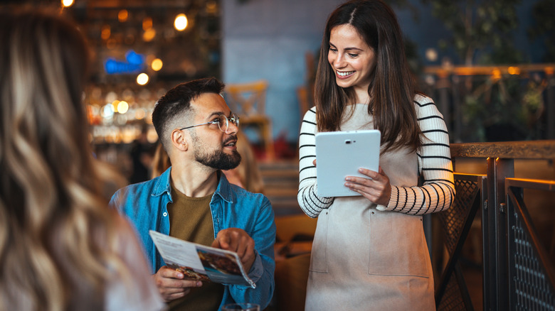 Smiling waitress taking an order from a man