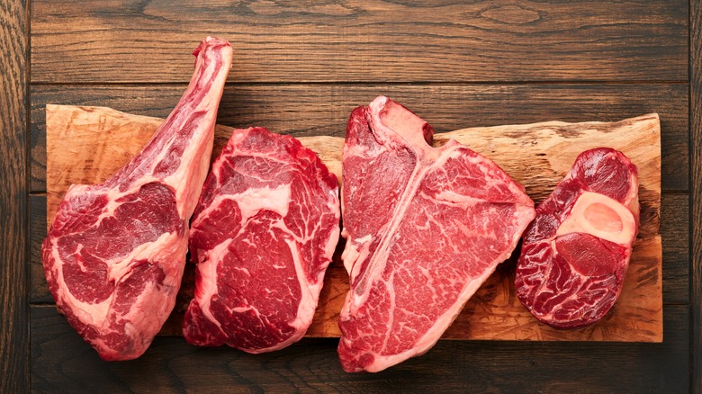 A selection of common steakhouse cuts on a wooden bench.