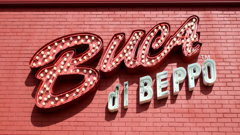 A bright Buca di Beppo sign on a brick wall