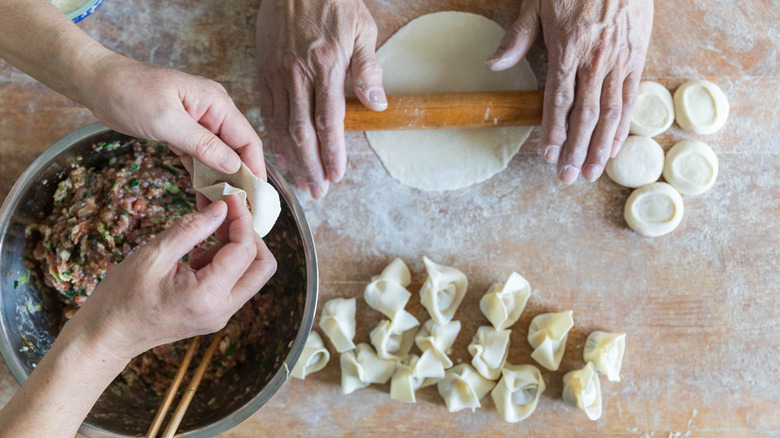 People rolling and filling ravioli