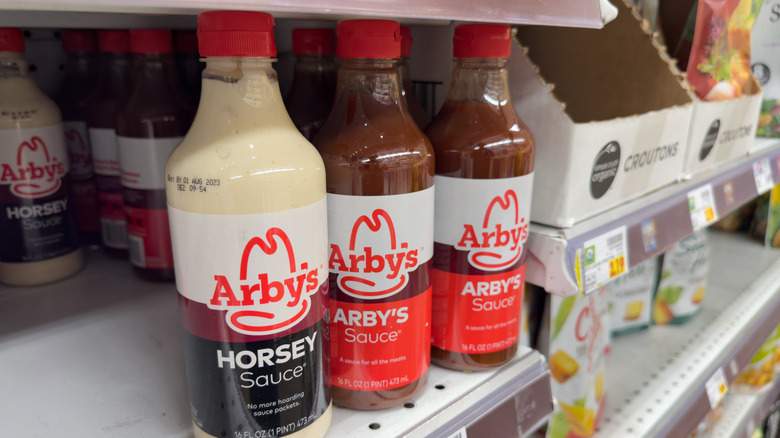 Arby's sauce bottles on a grocery store shelf
