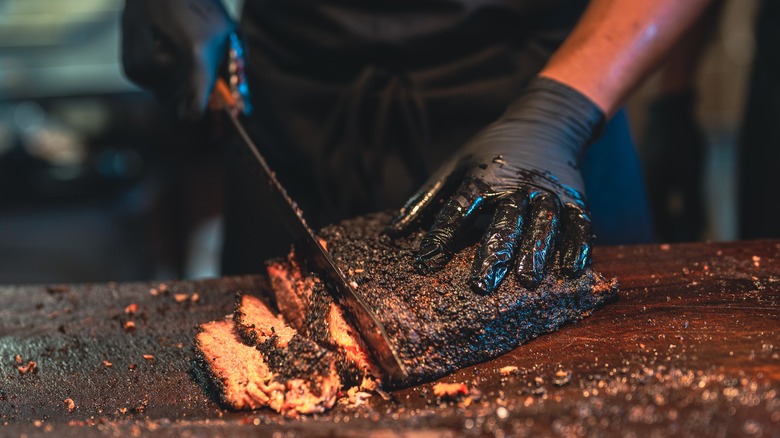 Man slicing slow-cooked brisket