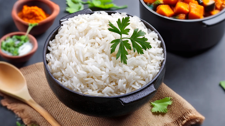 A bowl of white rice garnished with parsley.