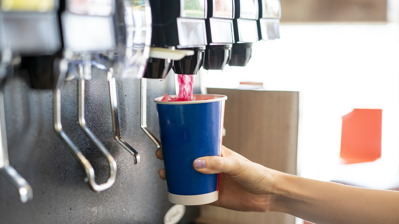 Pouring fizzy drink into cup