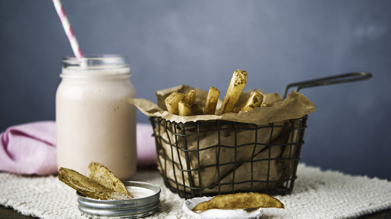 Basket of fries beside strawberry shake