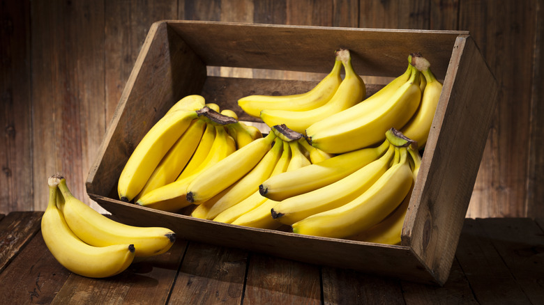 bunches of bananas in wooden crate
