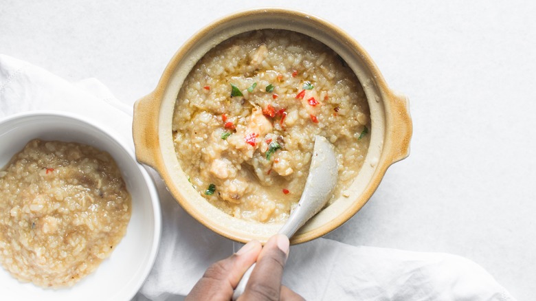 Person spooning congee out of bowl