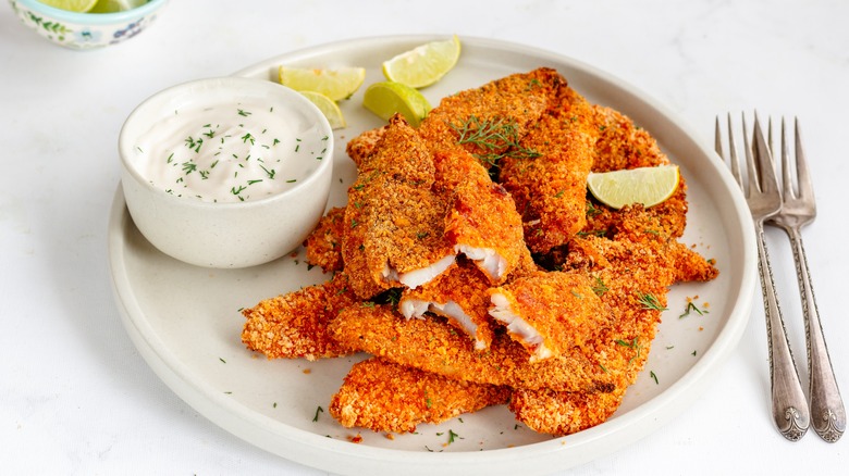 Battered white fish with sauce and limes