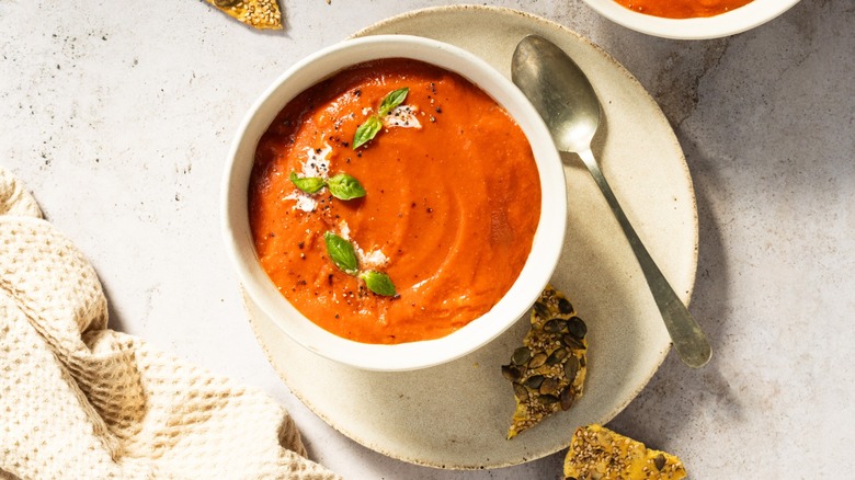 A bowl of tomato soup with a spoon