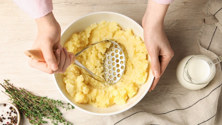 Person using potato masher