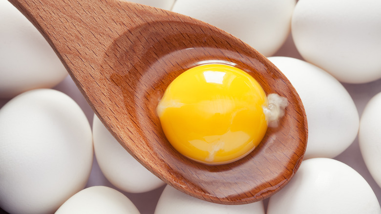 egg yolk in wooden spoon