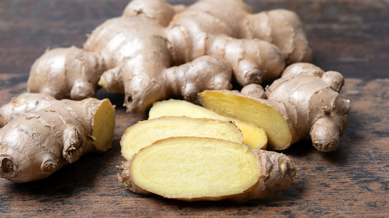 ginger root and ginger slices on a wooden table