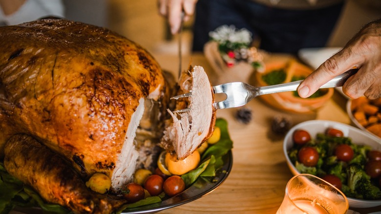 A man carves a beautiful roast chicken