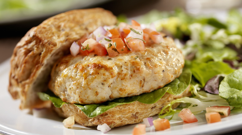 Closeup of a plump turkey burger on a bun.